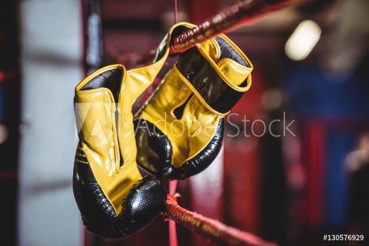 Bild på Yellow boxing gloves hanging off the boxing ring